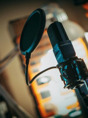 Close-up of a microphone with pop filter in a recording studio, perfect for music production visuals.